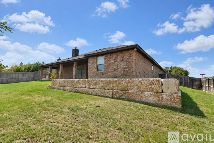A house with a stone wall in front of it.