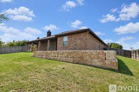 A house with a stone wall in front of it.
