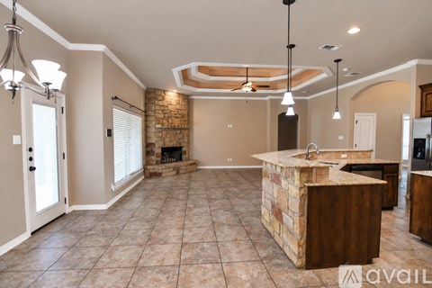 A kitchen with a stone counter top and a fireplace.