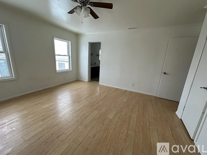 A room with wooden flooring and a ceiling fan.