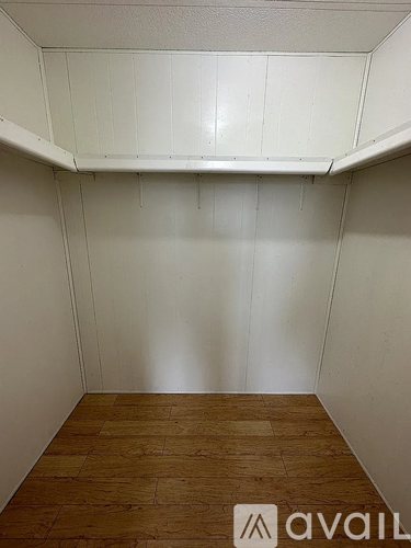 A room with wooden flooring and white walls.