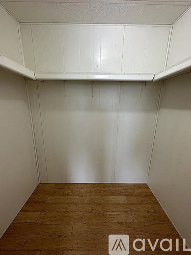 A room with wooden flooring and white walls.