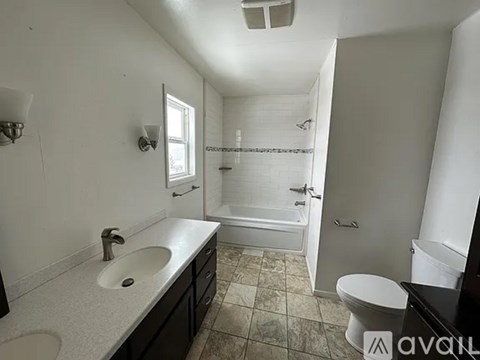 A bathroom with a sink, toilet, and bathtub.