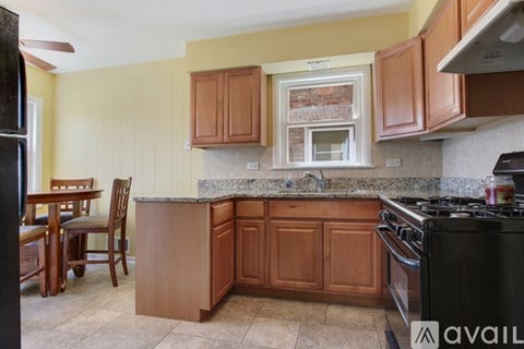 A kitchen with wooden cabinets and a black stove top oven.