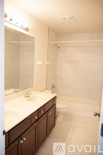 A bathroom with a sink, mirror, toilet and bathtub.