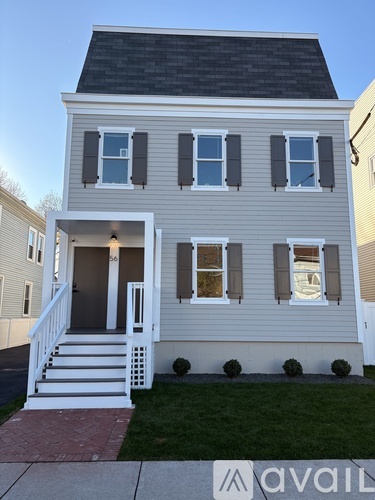 A two-story house with a front porch and a garage door.