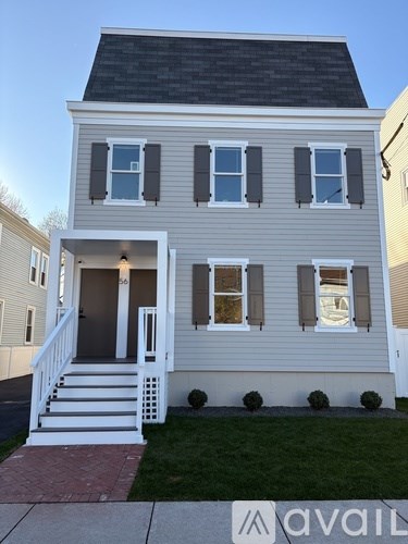 A two-story house with a front porch and a garage door.
