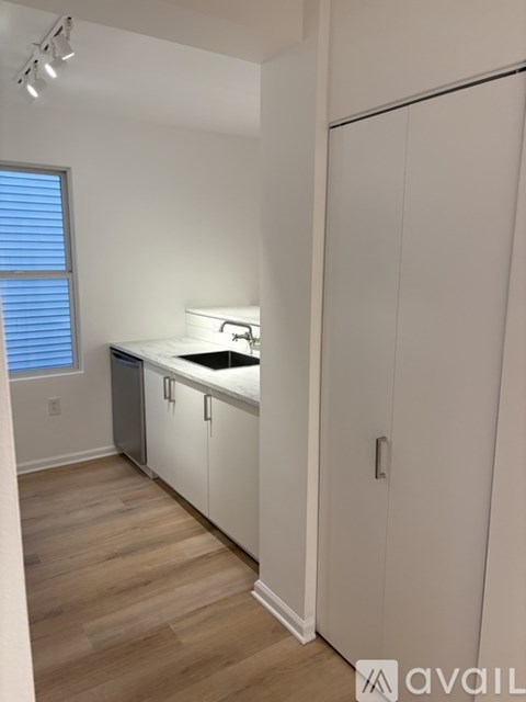 A kitchen with white cabinets and a marble countertop.