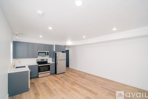 A kitchen with wooden floors and a refrigerator.