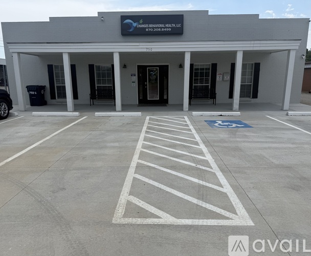 A parking lot in front of a building with a blue sign that says "Change Renewal Health LLC".