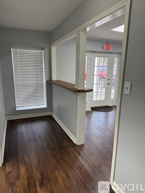 A room with a wooden floor and a white door with a window above it.