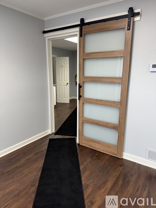 A room with a black carpet and a wooden door.
