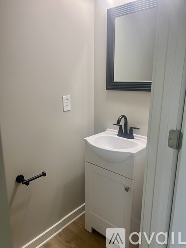 A white sink with a black faucet is in a bathroom.