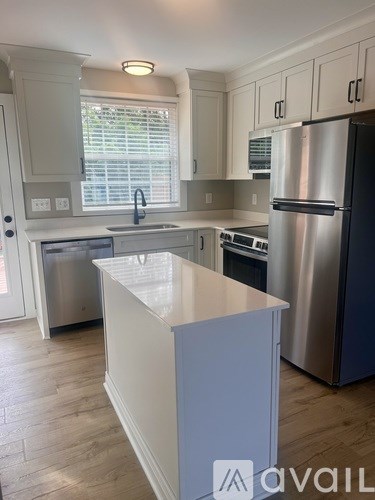 A kitchen with a white island and stainless steel appliances.