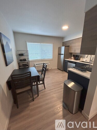 A kitchen with a dining table and chairs.