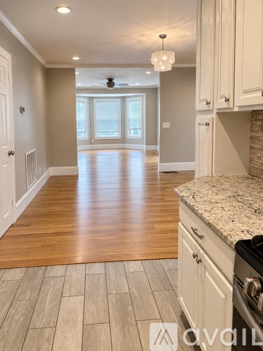 A kitchen with a wooden floor and white cabinets.