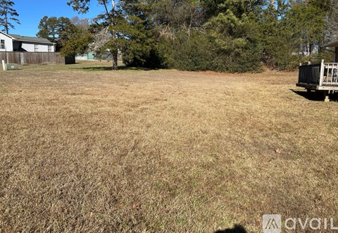 A field with dry grass and a shed in the background.