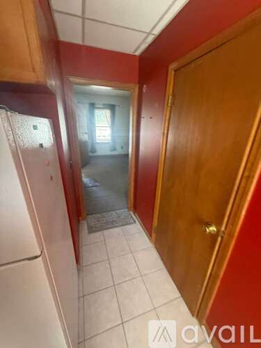 A hallway with red walls and a white door.
