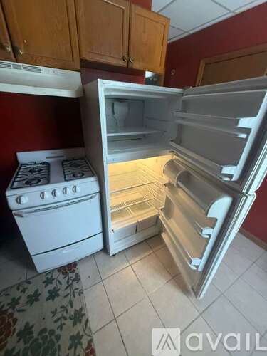 A white refrigerator and stove are in a kitchen.