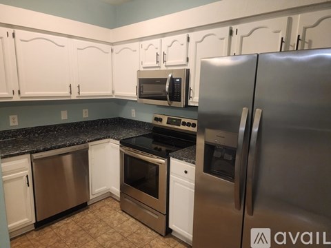 A kitchen with a stainless steel refrigerator, microwave, oven, and dishwasher.