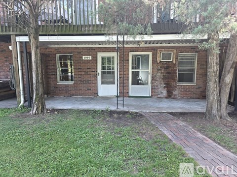 A brick building with a white door and windows.
