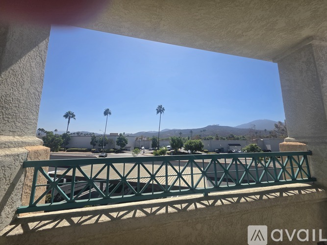 A bridge with a metal railing is in the foreground of a sunny day.
