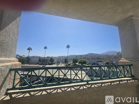 A bridge with a metal railing is in the foreground of a sunny day.