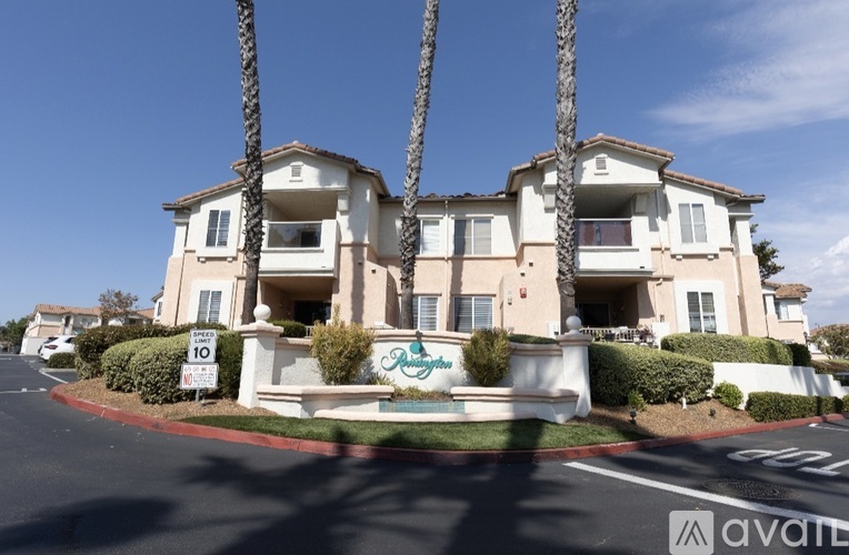 A large two-story building with a sign that says "For Sale" in front of it.