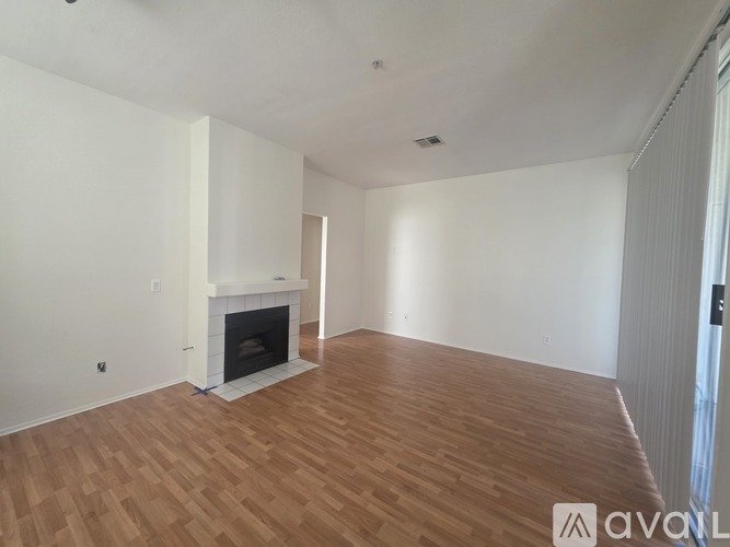 A room with a fireplace and wooden flooring.