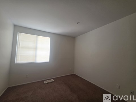 A room with a window and a carpet.