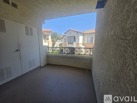 A balcony with a view of houses and a clear sky.