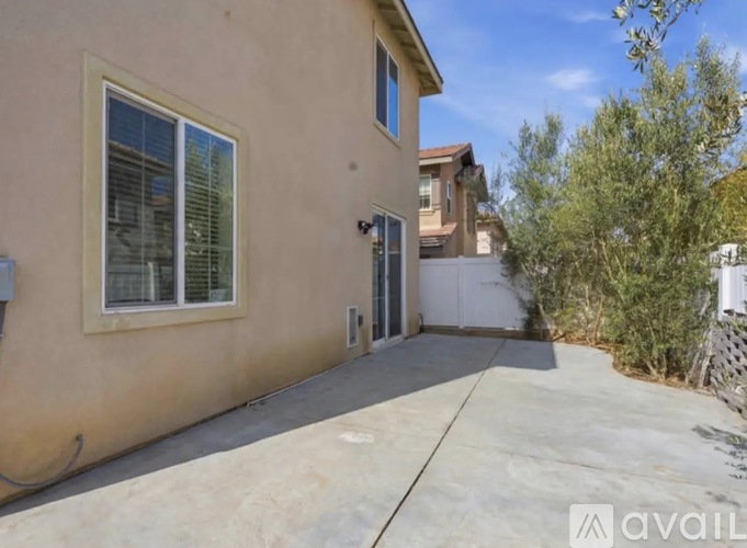 A beige house with a window and a door is for sale.
