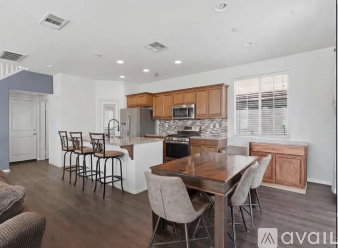 A modern kitchen with a dining table and chairs.