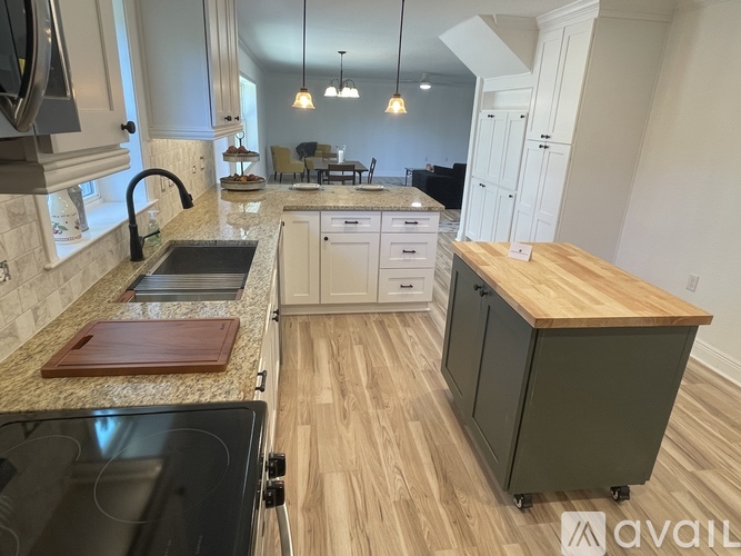A kitchen with a granite countertop and a wooden island.