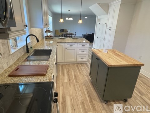 A kitchen with a granite countertop and a wooden island.