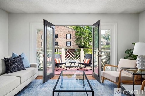 A living room with a couch, chairs, and a glass table.