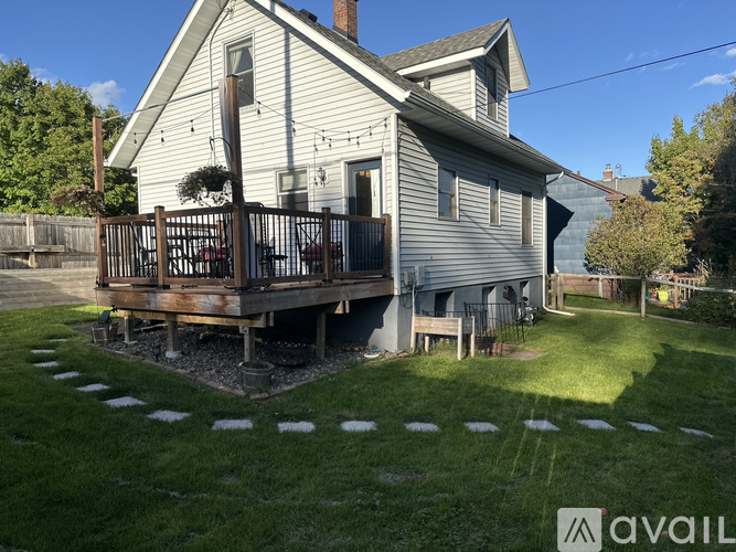 A house with a white exterior and a deck in the backyard.