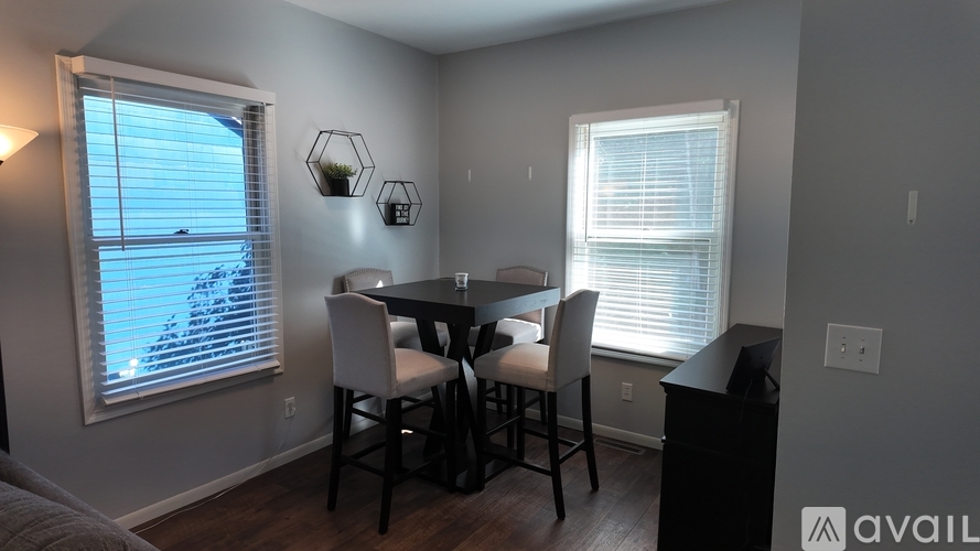 A dining room with a table and chairs.