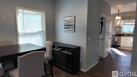 A modern kitchen with a dining table and chairs in the foreground.