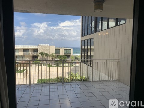 A balcony with a view of the ocean and buildings.