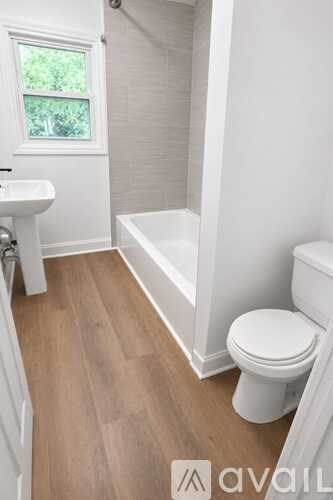 A white toilet sits next to a white sink in a small bathroom.