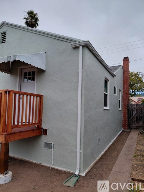 A house with a grey exterior and a wooden balcony.