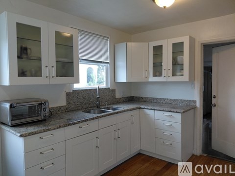 A kitchen with white cabinets and a granite countertop.