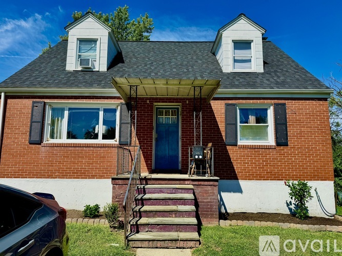 A red brick house with a blue door and a covered porch.