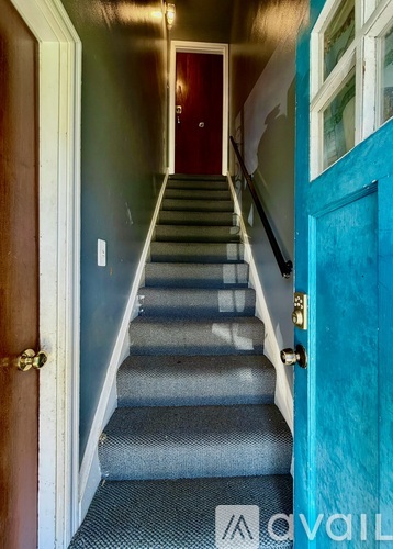 A staircase with a blue door on the right.