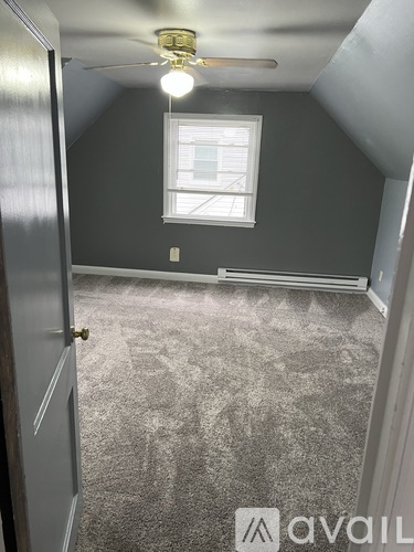 A room with a ceiling fan and a window.