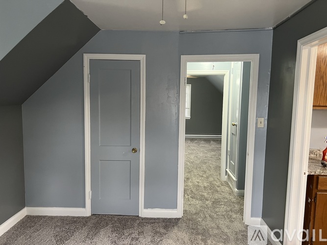 A room with a grey door and a carpeted floor.