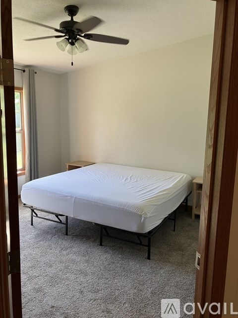 A bedroom with a bed and a ceiling fan.