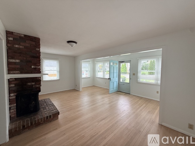 A living room with a fireplace and wooden floors.
