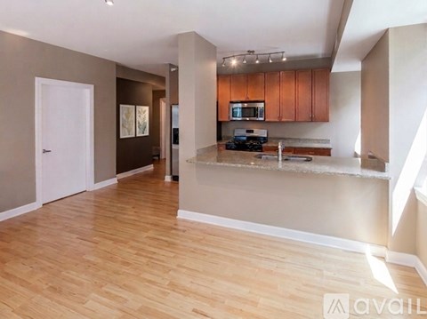 A kitchen with wooden floors and a countertop with a microwave and oven.